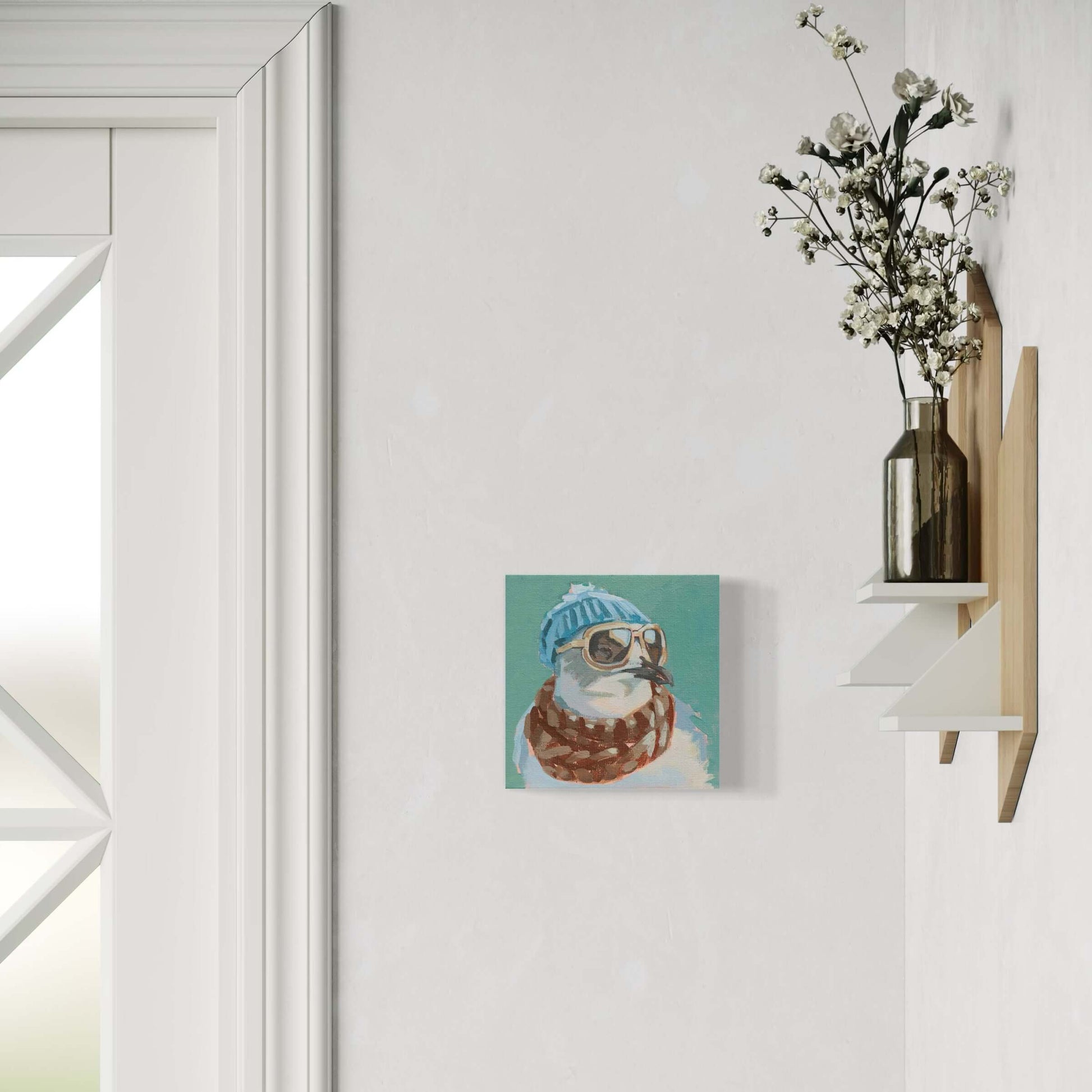 Cute dog wearing a blue beanie and scarf, stylishly displayed on a wall with decorative shelf and flowers.